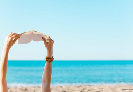 Blick auf das Meer, Strand, Arme die Buch halten