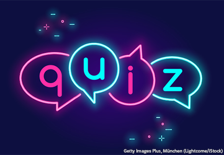 Das Wort Quiz in Leuchtbuchstaben auf dunkelblauem Hintergrund